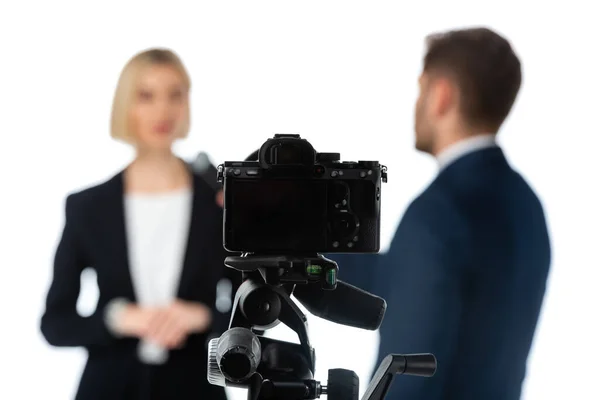 Selective focus of digital camera near couple of news anchors on blurred background isolated on white — Stock Photo