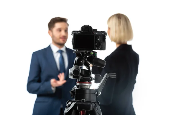 Selective focus of professional digital camera near news presenters working on blurred background isolated on white — Stock Photo