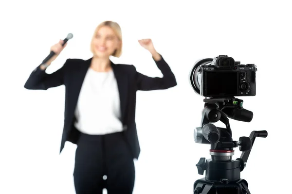 Selective focus of digital camera near news anchor showing success gesture on blurred background isolated on white — Stock Photo