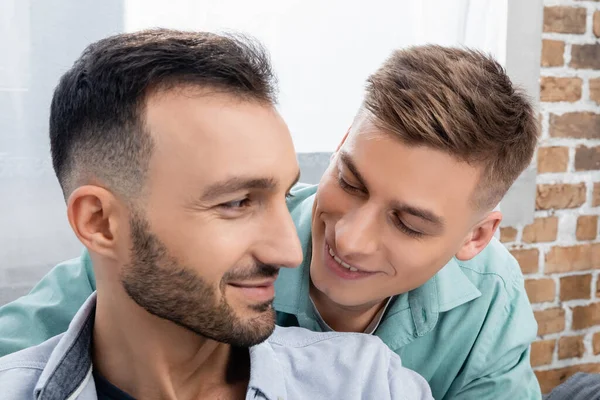 Feliz mismo sexo familia sonriendo y mirando el uno al otro - foto de stock