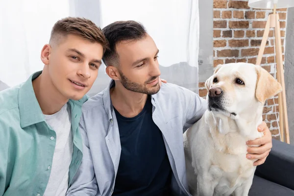 Mann blickt in die Kamera neben Ehemann und Labrador — Stockfoto