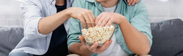 Partial view of same sex couple watching movie with popcorn, banner — Stock Photo