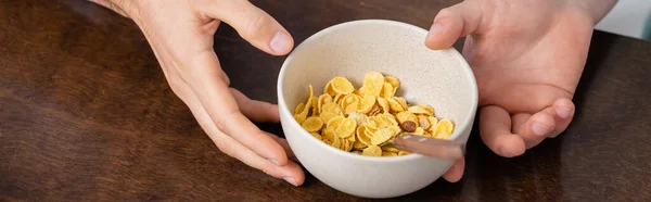 Cropped view of homosexual men holding bowl with corn flakes, banner — Stock Photo