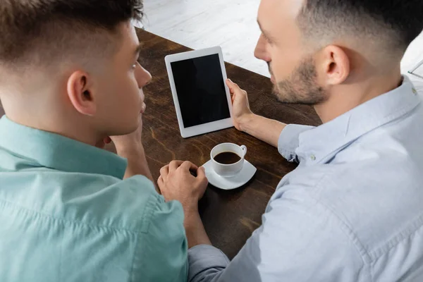 High angle view of homosexual man holding digital tablet with blank screen near husband — Stock Photo