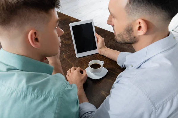 Vue grand angle de l'homme homosexuel tenant tablette numérique avec écran blanc près du mari — Photo de stock