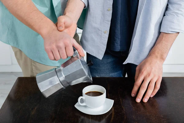 Partial view of homosexual man pouring coffee from coffee pot near husband — Stock Photo