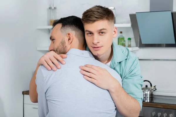 Homosexual man calming and hugging worried husband at home — Stock Photo