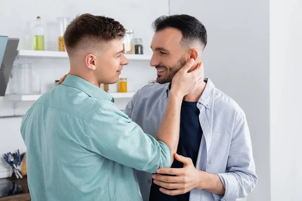 Счастливый гомосексуалист обнимает мужа дома — стоковое фото