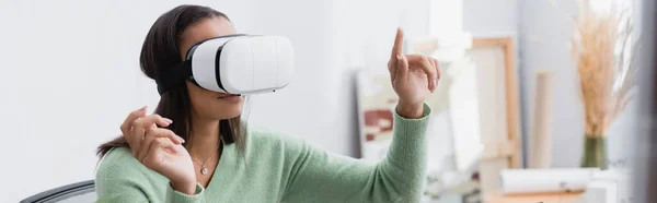 Afrikanisch-amerikanischer Architekt zeigt mit dem Finger, während er zu Hause im vr-Headset spielt, Banner — Stockfoto