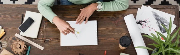 Vista parcial del arquitecto afroamericano trabajando con divisor y cuaderno de bocetos en casa, pancarta - foto de stock