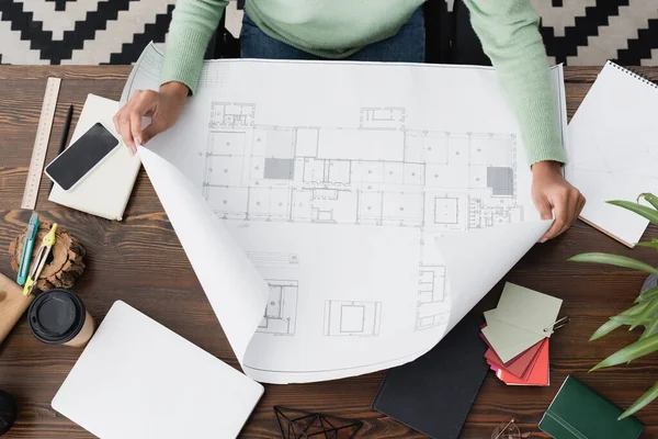 Top view of african american architect working with blueprint at home — Stock Photo