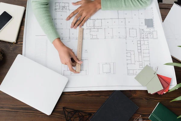 Top view of african american architect measuring blueprint with ruler — Stock Photo