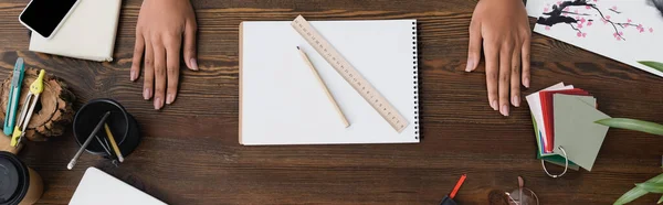 Vue du haut des mains du décorateur d'intérieur près du carnet de croquis, crayon et règle sur le bureau, bannière — Photo de stock