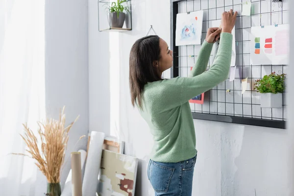 Africano americano designer de interiores fixação pintura na parede em casa — Fotografia de Stock