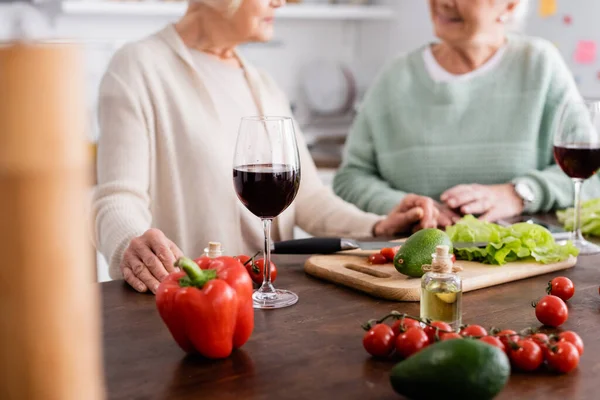 Vue recadrée des amis aînés près des légumes frais sur la table — Photo de stock