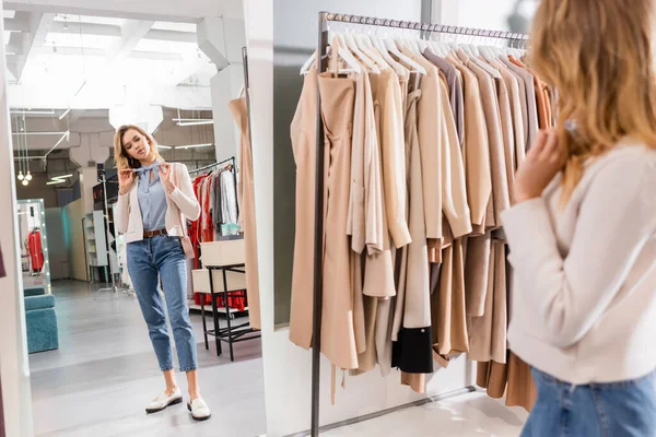 Junge Frau blickt im Showroom in den Spiegel — Stockfoto