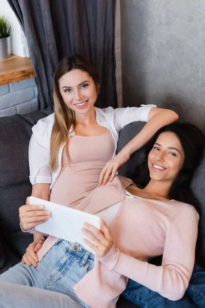 Happy lesbian couple watching movie on digital tablet at home — Photo de stock