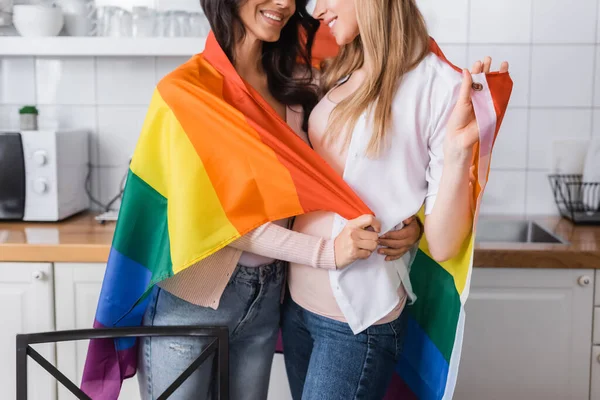 Cropped view of happy lesbian couple holding lgbt flag - foto de stock