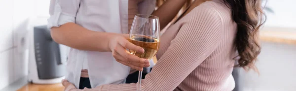 Cropped view of woman holding glass of wine near girlfriend, banner - foto de stock