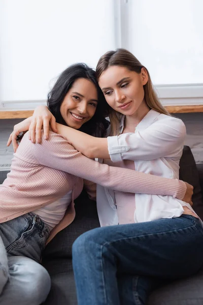 Fröhliches lesbisches Paar umarmt sich im Wohnzimmer — Stockfoto