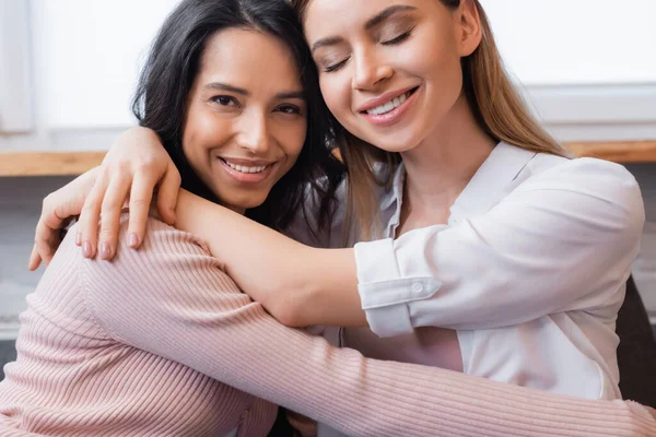 Glückliches lesbisches Paar umarmt sich im Wohnzimmer — Stockfoto