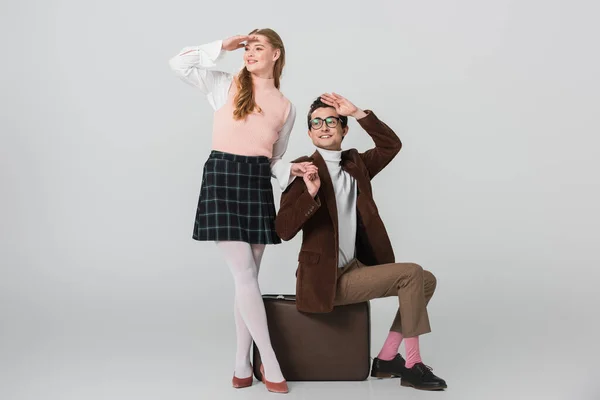 Young travelers in retro outfit looking away on grey background — Stock Photo