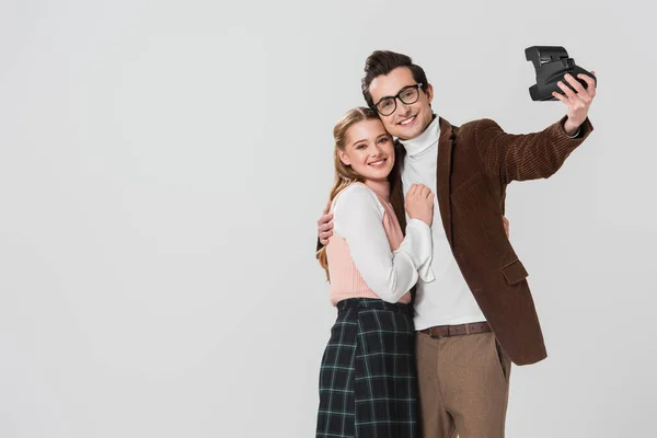 Jovem, casal à moda antiga levando selfie na câmera vintage isolado em cinza — Fotografia de Stock