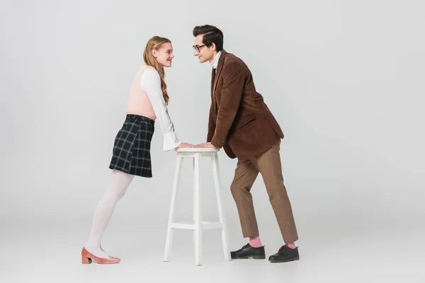 Side view of vintage style couple looking at each other on grey background — Stock Photo