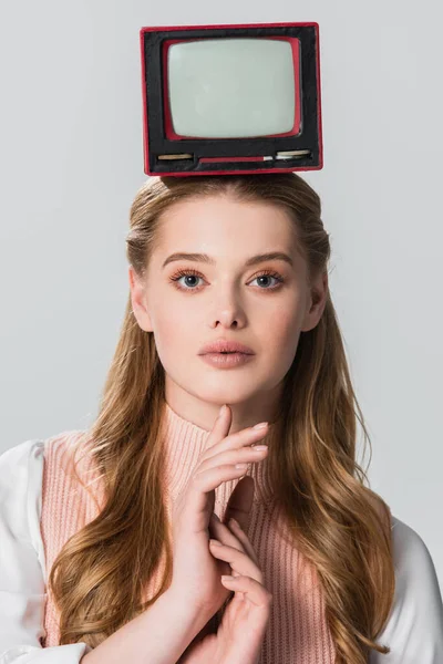 Pretty woman posing with portable vintage tv on head isolated on grey — Stock Photo