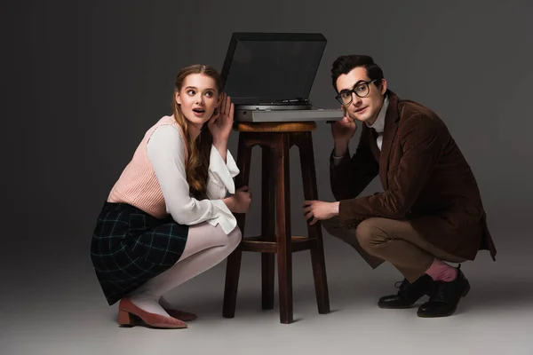 Excited couple listening music near record player on dark grey background — Stock Photo