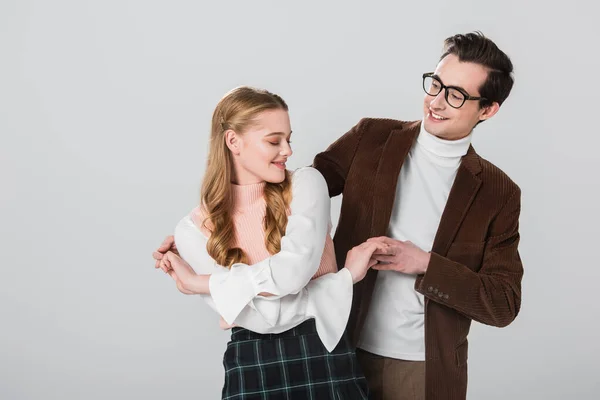 Vieil homme à lunettes dansant avec jeune copine isolée sur gris — Photo de stock