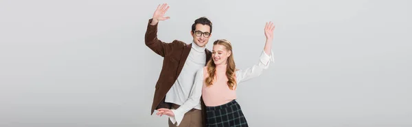 Glückliches Paar in Vintage-Kleidung tanzt mit erhobenen Händen isoliert auf grauem Banner — Stockfoto