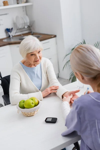 Aus der Vogelperspektive betrachtet, wie eine Krankenschwester einer älteren Diabetikerin Insulin spritzt — Stockfoto