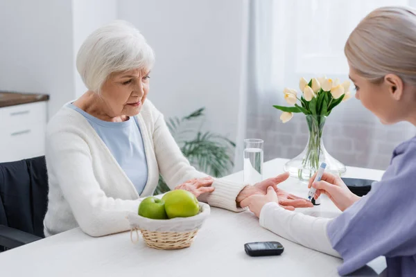 Junge Krankenschwester spritzt Diabetikerin zu Hause Insulin — Stockfoto