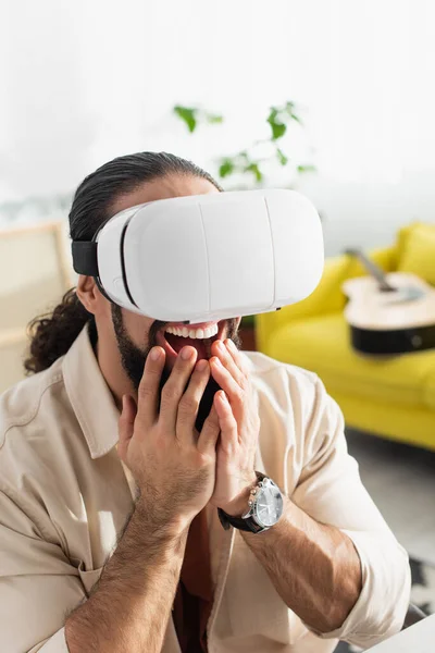 Scared latin man gaming in vr headset and screaming in living room — Stock Photo