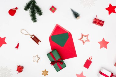 Kırmızı zarfın en üst görüntüsü, beyaz arka planda noel yakındaki mücevherler.