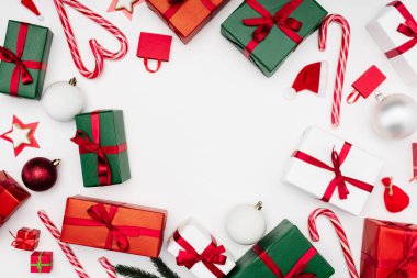 Çok renkli hediye kutuları, baston şekerler ve beyaz üzerinde noel mücevherleri.