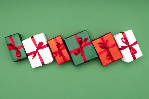 Top View Multicolored Gift Boxes Red Ribbons Green Background — Stock Photo, Image