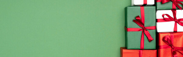 вид сверху на красочные подарочные коробки с красными лентами на зеленом фоне, заголовок сайта