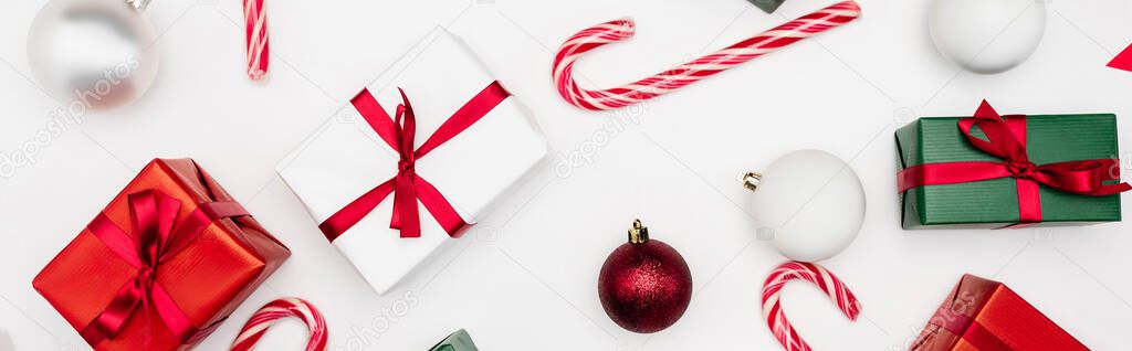 website header of gift boxes, christmas balls and candy canes on white background