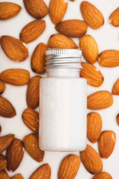 Bovenaanzicht Van Fles Met Hydraterende Melk Amandelen Witte Achtergrond — Stockfoto