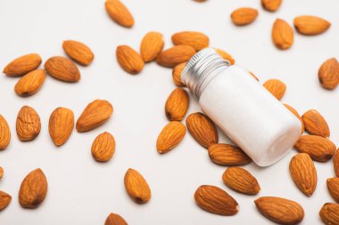 almonds and fresh homemade almond milk in bottle on white surface clipart