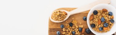 Fındıklı, yaban mersinli ve beyaz pankartta izole edilmiş kuru kayısılı lezzetli granola manzarası.