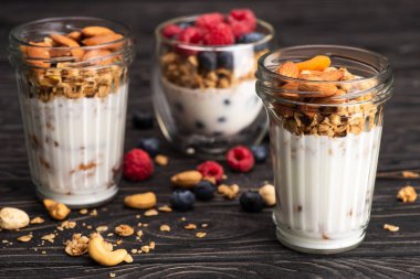 Lezzetli granola, kurutulmuş kayısı, fındık ve yoğurt. Ahşap yüzey, bulanık arka plan.