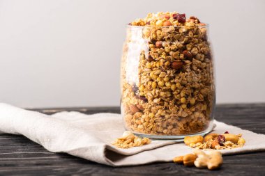 Gri üzerine izole edilmiş peçetenin üzerinde cam içinde nefis granola.