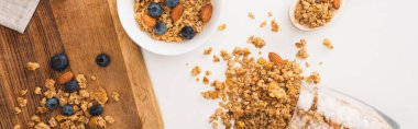 Fındıklı, yaban mersinli ve beyaz pankartta izole edilmiş kuru kayısılı lezzetli granola manzarası.