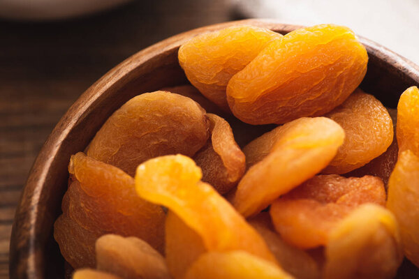 closeup of delicious dried apricots in wooden bowl