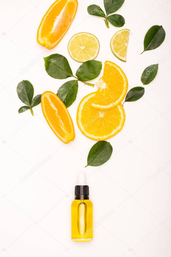 bottle of citrus essence near orange slices and rose leaves on white surface