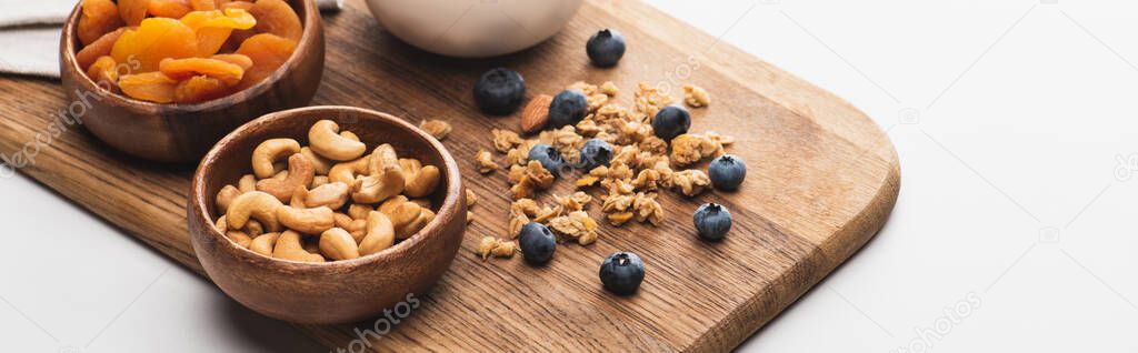 delicious granola with nuts,dried apricots and blueberry on white background, banner