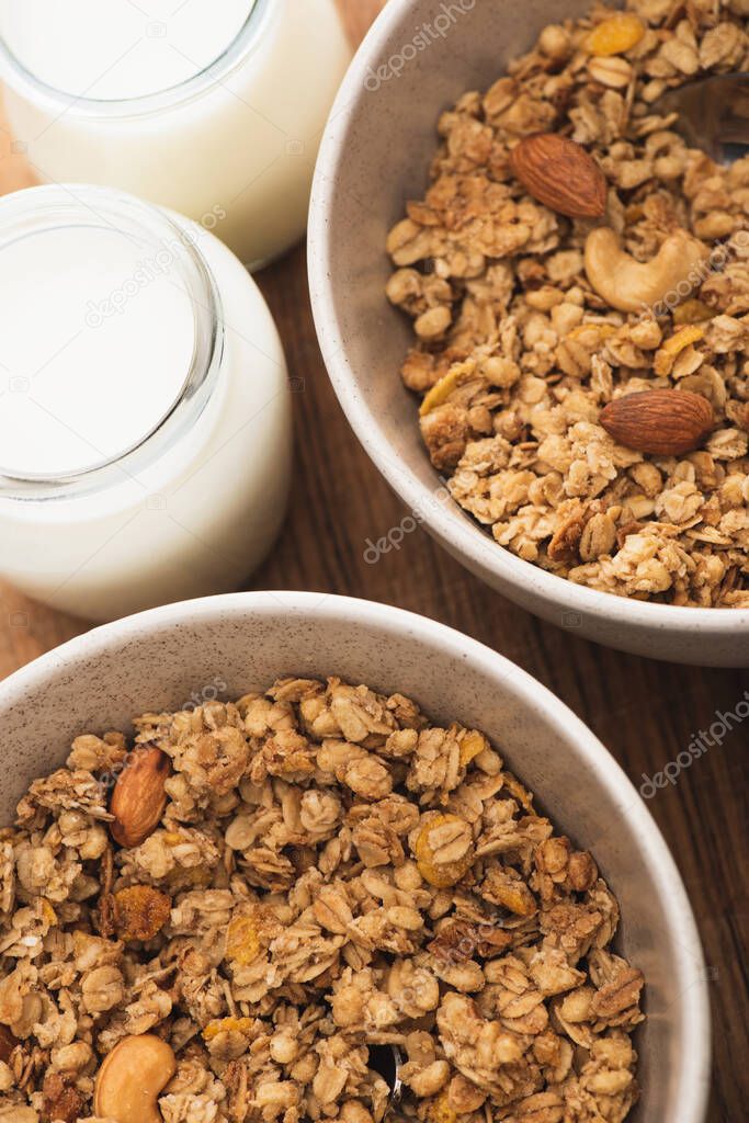 closeup of delicious granola with nuts and yogurt on wooden board